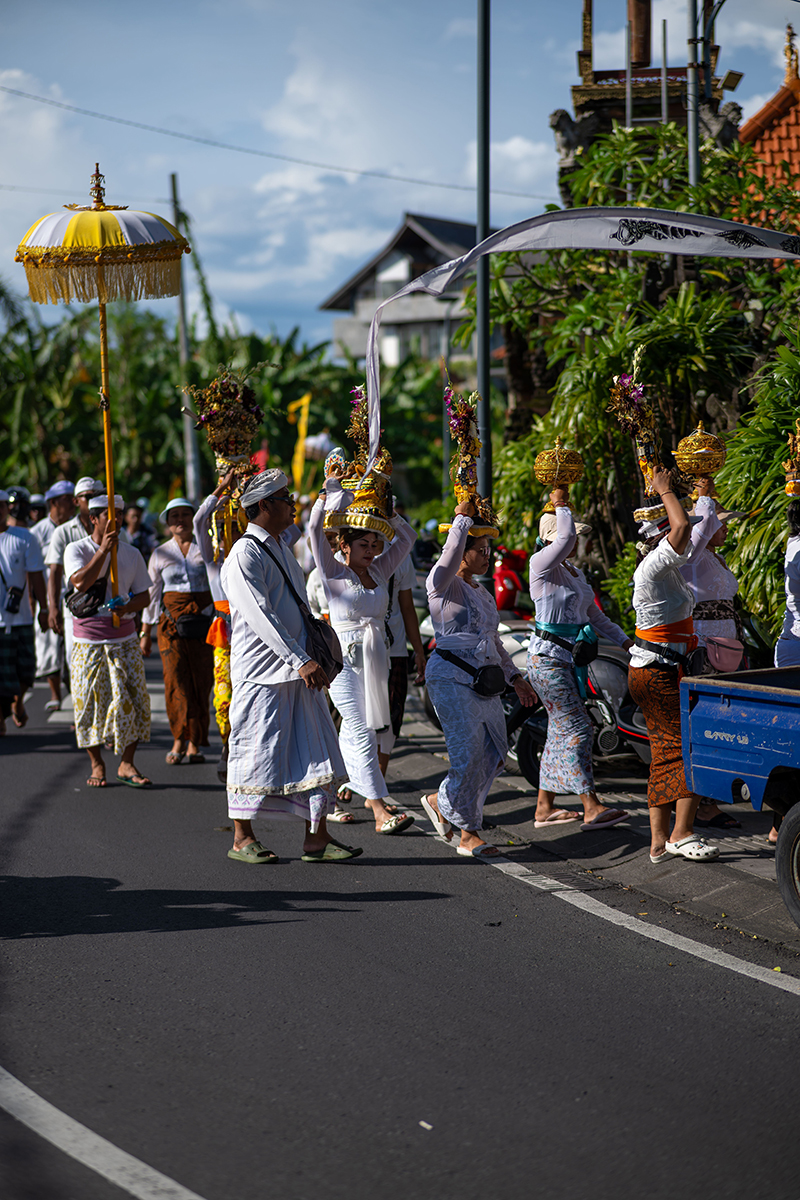 Temple ceremony with traditional gamelan music and ceremonial umbrellas