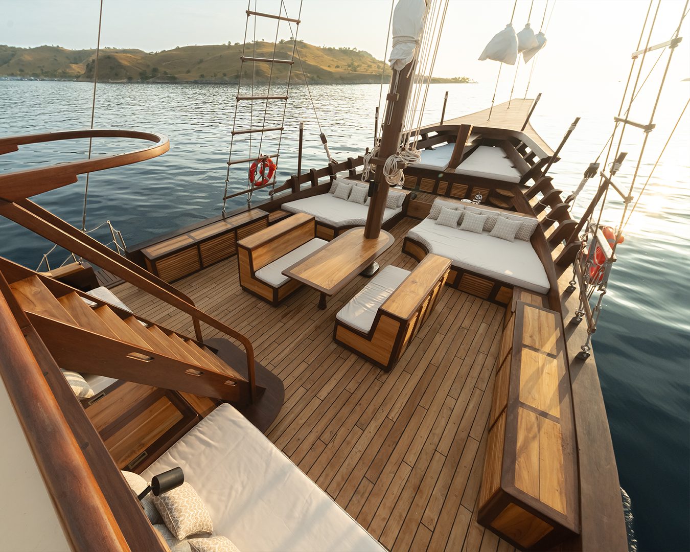 Teak deck and open lounge area of a Phinisi liveaboard in Komodo